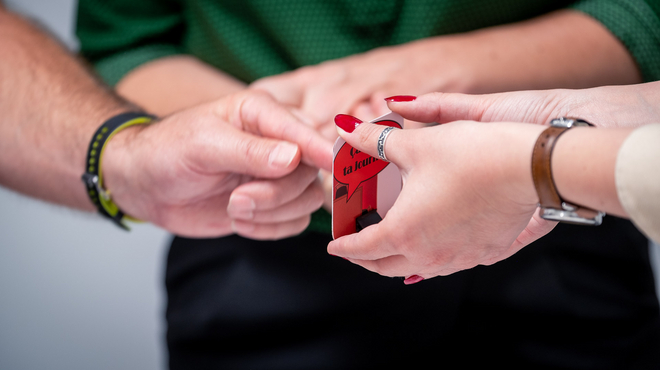 une personne touche du doigt une carte tenue à deux mains par quelqu'un d'autre.